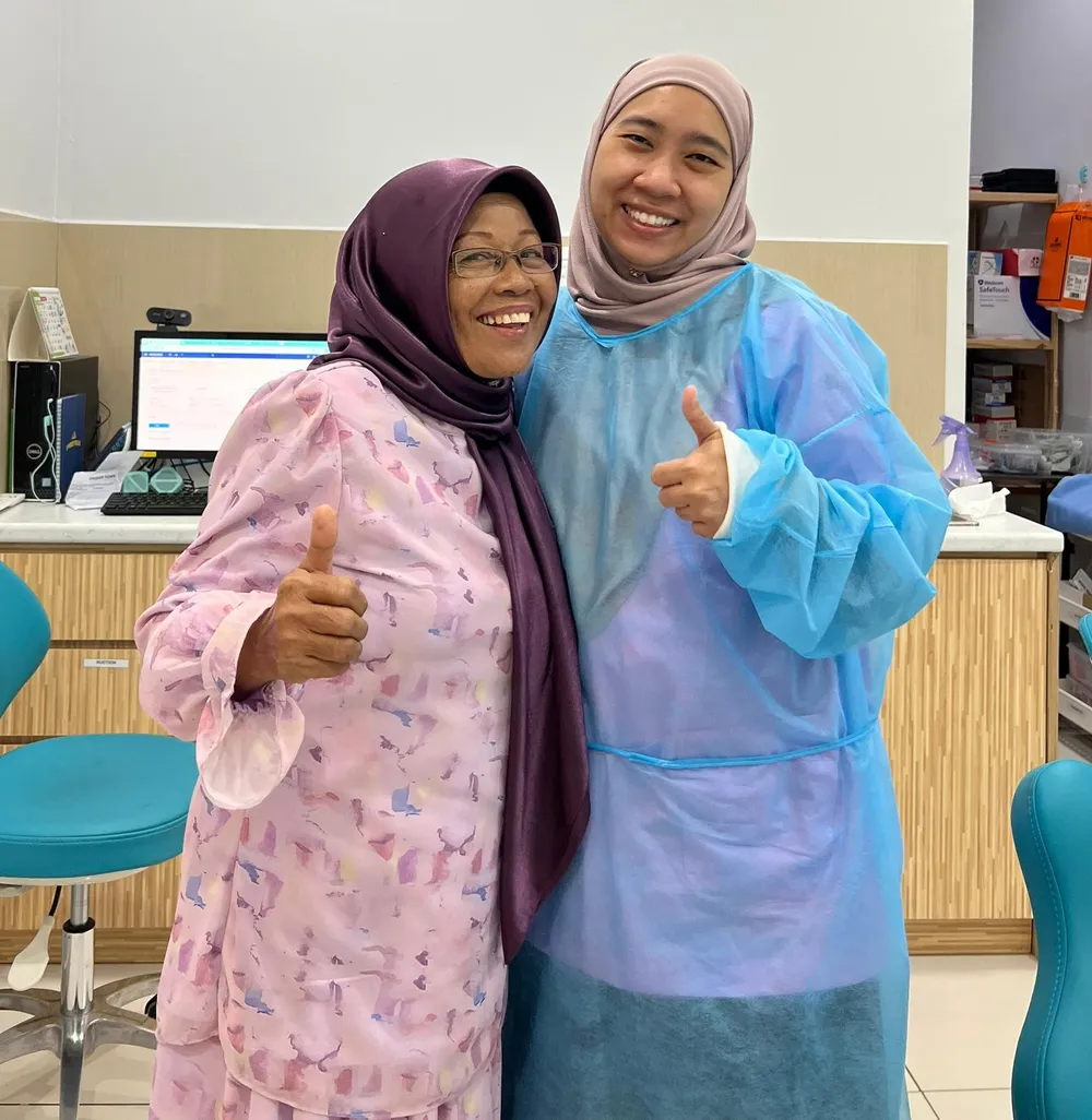 Doktor Everglo bersama pesakit warga emas yang tersenyum di klinik
