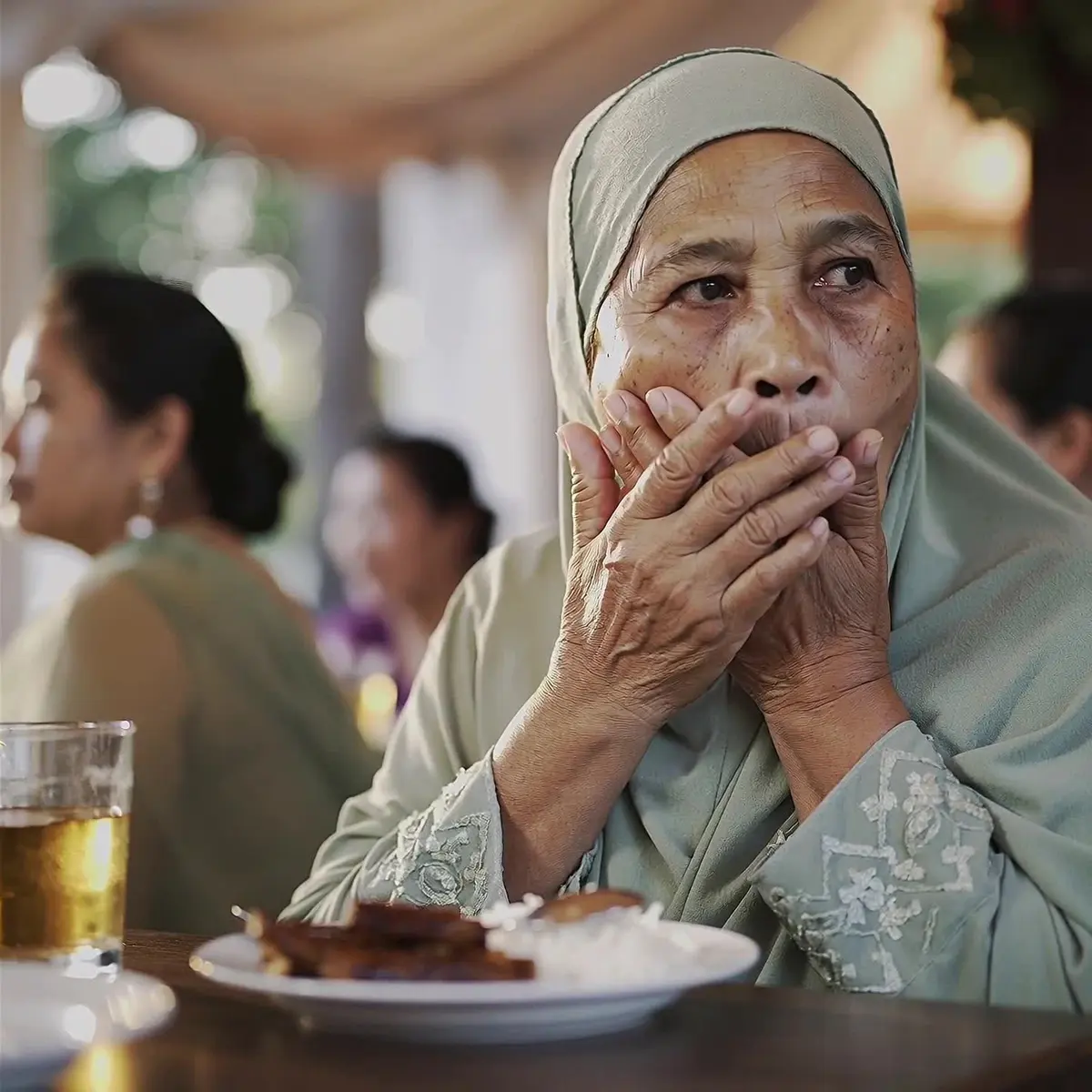 Wanita warga emas tutup mulut di kenduri