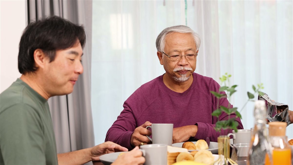 Dua lelaki makan bersama di meja