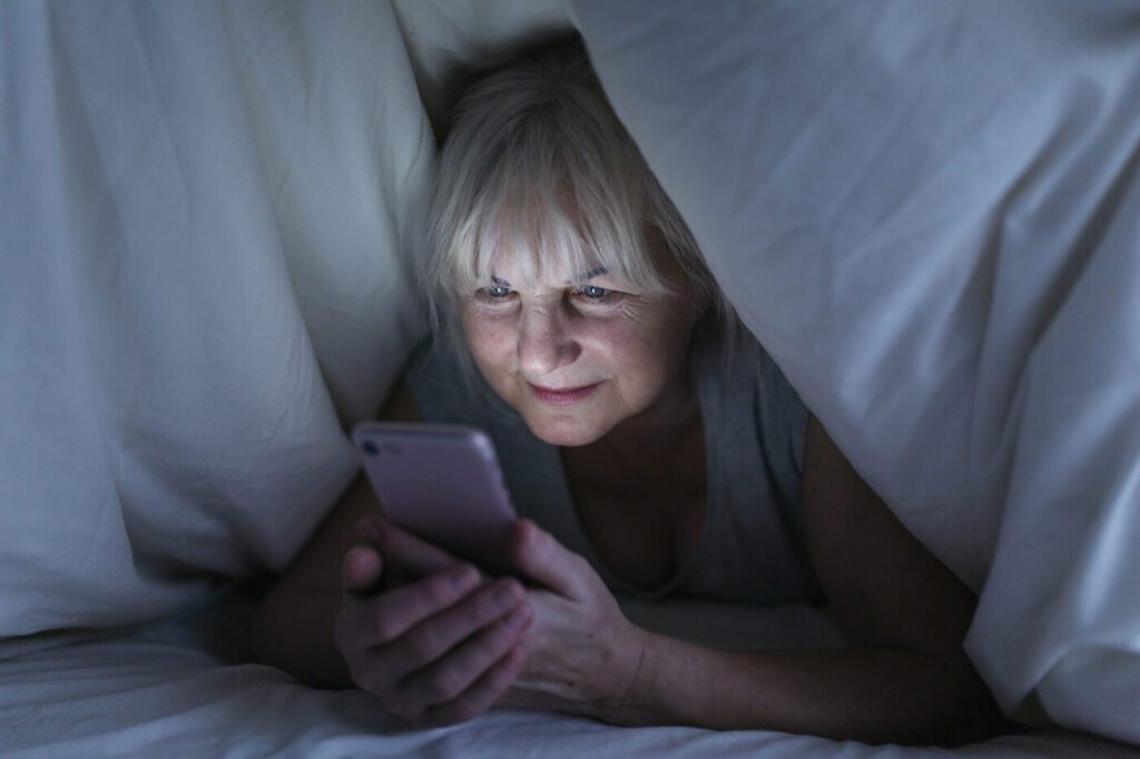 Wanita berjaga malam mencari maklumat gigi palsu di telefon
