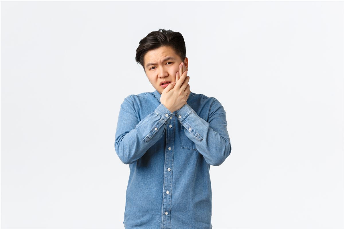 Lelaki memegang pipi kerana sakit gigi dan gusi